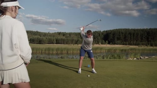 Man Practicing Golf Swing Outdoors on Sunny Day