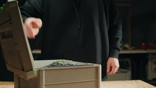 Man Attaches Drill Bit to Cordless Drill