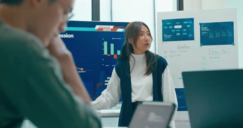 Group of Asian businesspeople work together leads business meeting uses presentation TV in office.