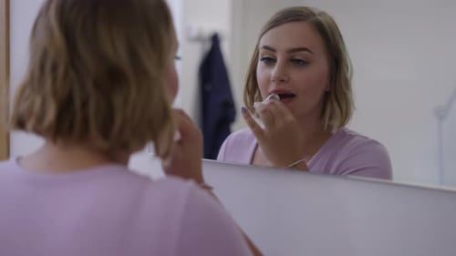 Beautiful Blonde Girl Removing Her Makeup in Front of the Mirror