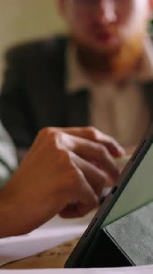 Closeup Collaboration with Digital Tablet As Colleagues Discuss Documents Point at Screen and Review