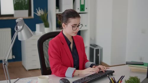 Businesswoman Working at Computer in Bright Office