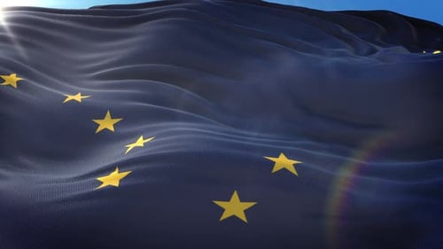 Waving Blue Flag with Golden Stars Against Clear Sky