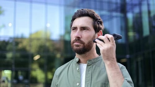 Smiling Man Using Smartphone in City Setting