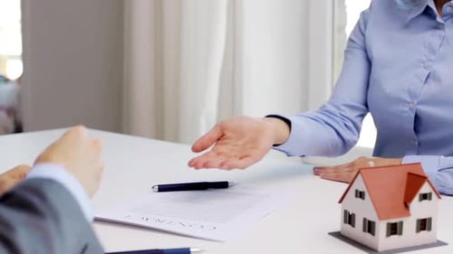 Man gives house keys to woman in office real estate deal concept