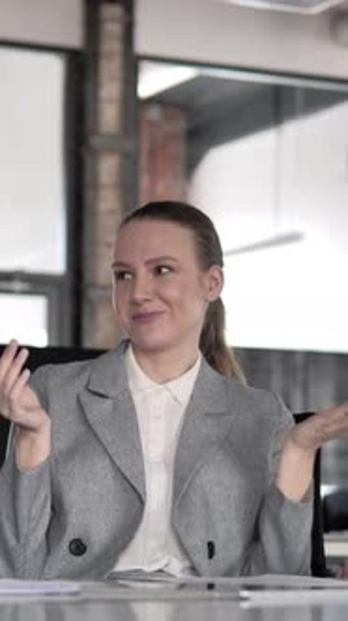 Businesswoman Explaining Project in Office Wearing Gray Suit