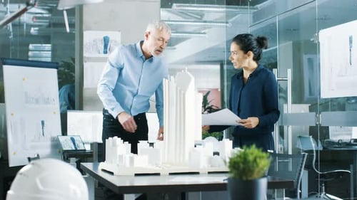 In the Architectural Bureau Female Engineer Brings Blueprints and Shows them to Senior Architect,