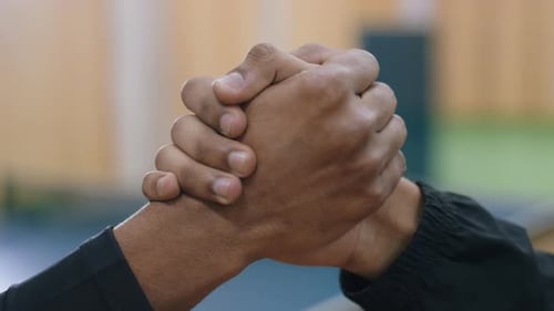 Close Up Strong Handshake Between Two People With Blurred Indoor Background