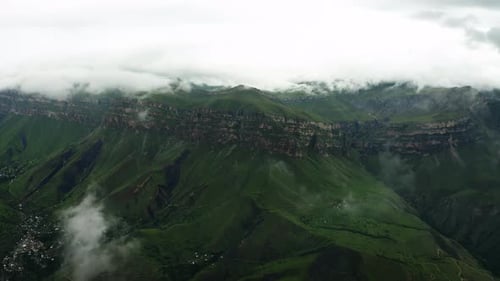 Misty Cliffs Over Green Valley Clouds Descend Upon Towering Cliffs Above a Verdant Mountain Valley