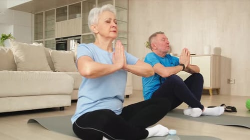 Senior Couple Meditating Together in Living Room