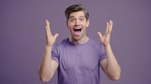 Excited Man Gesturing on Purple Background