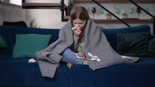 Sick Woman with Blanket on Couch at Home