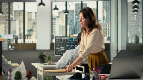 Une secrétaire aide ses collègues à gérer des fichiers archivés dans un environnement de travail moderne