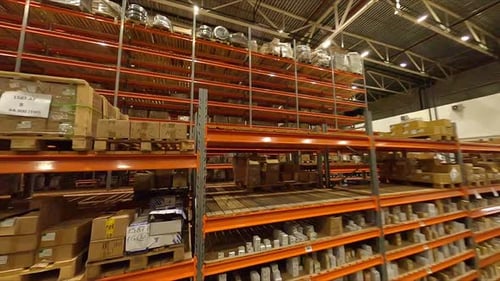 Motion Through Shelving Units with Cardboard Boxes in Store