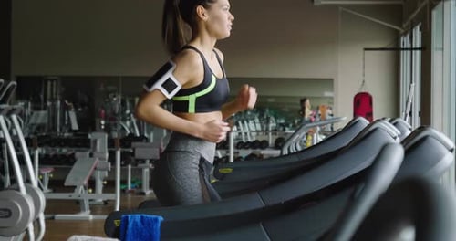 Woman Runs on Treadmill at the Gym