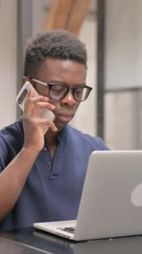 Young African Man Talking on Phone in Office