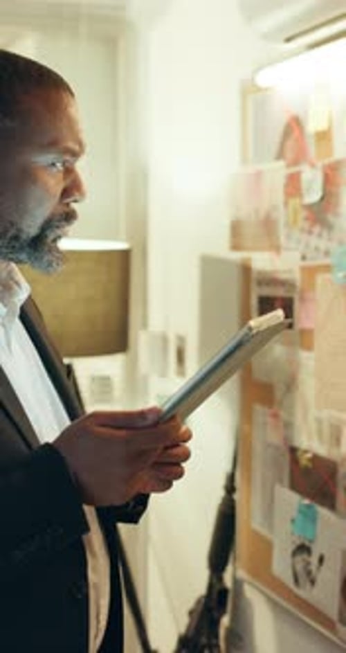 Man Reviews Evidence on Board in Office