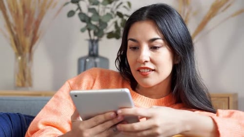 Woman Using Tablet Device on Sofa
