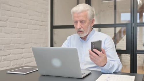 Senior Man Working with Technology in Office