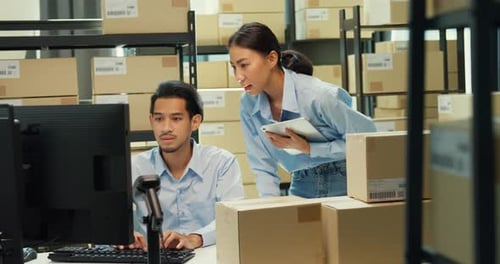 Asian man and lady computer and barcode machine scanner discuss stock detail customer online.