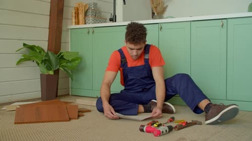 Man Assembling Furniture in a Home Kitchen
