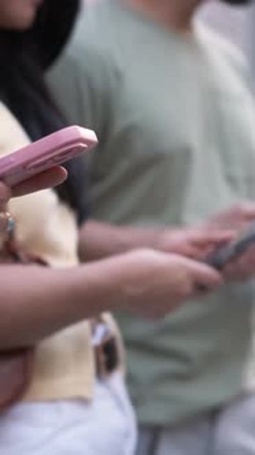 Anonymous Friends Using Smartphones While Standing in City