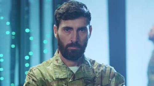 Serious Man in Military Uniform Stares at Camera