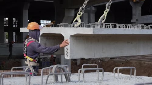 Construction Worker Guiding Precast Concrete Slab Installation