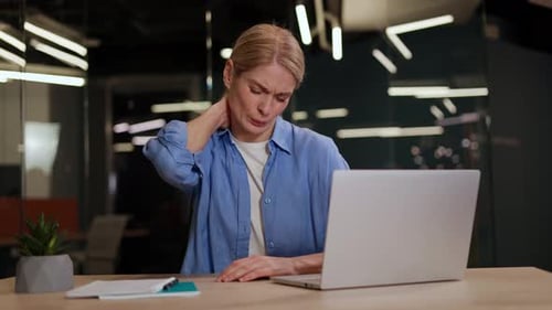 Professional Woman Feeling Pain in Neck After Working on Laptop in Work Area
