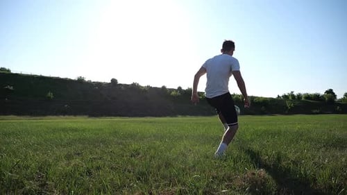 Sportsman Juggling Soccer Ball on Stadium at Sunny Day Young Man Kicking Ball at Green Field