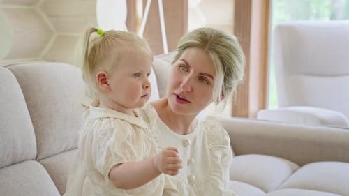 Mother and Toddler Girl Talking on Sofa