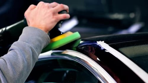Closeup of the Hands of a Car Mechanic at a Service Station Doing the Final Polishing to Shine