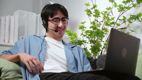 Young Man Video Conferencing at Home on Laptop