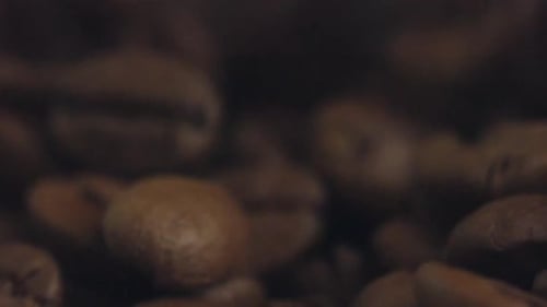 Roasted coffee beans piled up close up