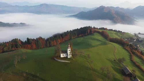Aerial view of church on green hill, Slovenia.