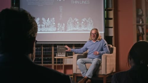 Author Presents Book to Audience in Cozy Room