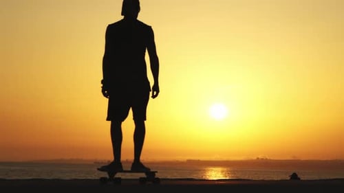 Skateboard Silhouette at Sunset by Ocean