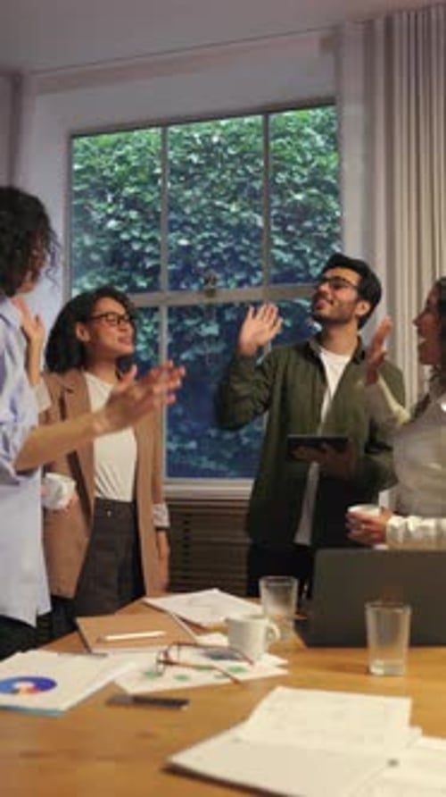 Diverse Business People Celebrating Success with High Five Gesture During Modern Office Meeting