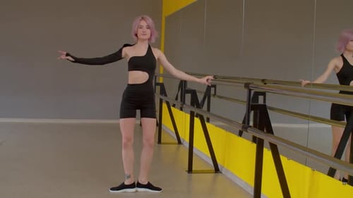 Young Woman Ballet Barre Workout in Dance Studio