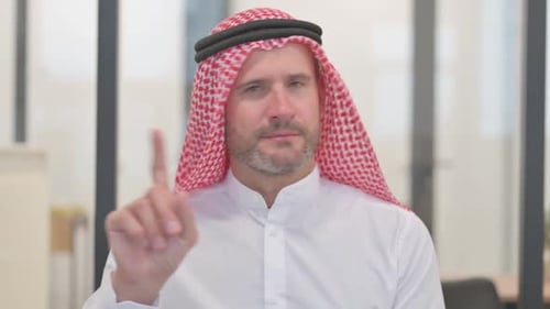 Man Shakes Finger While Wearing Headscarf