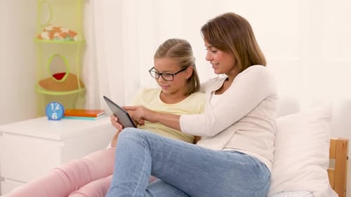 People, Family And Technology Concept - Happy Mother And Daughter With Tablet Pc Computer At Home