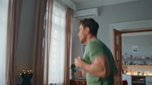 Energetischer Sportler trainiert zu Hause aus nächster Nähe, begeisterter junger Mann, der springt