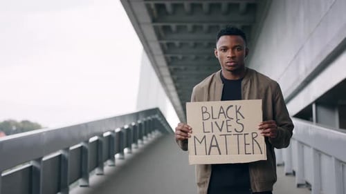 Serious Man Holding Black Lives Matter Sign Outdoors
