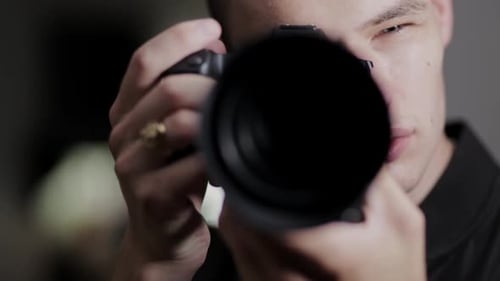 Male Photographer Raises Camera To Capture A Beautiful Portrait Shot In The Studio - close up