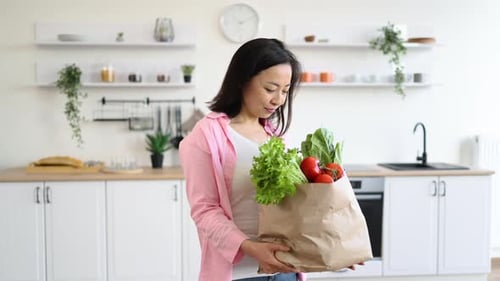 Woman with Groceries in Kitchen
