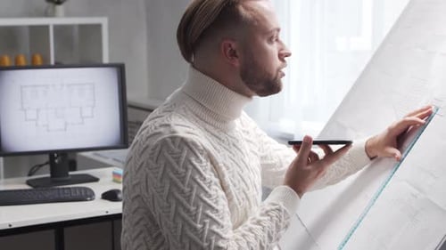 Un architecte concentré travaille dans un loft à l'aide d'une planche à dessin sur le lieu de travail d'un jeune ingénieur moderne