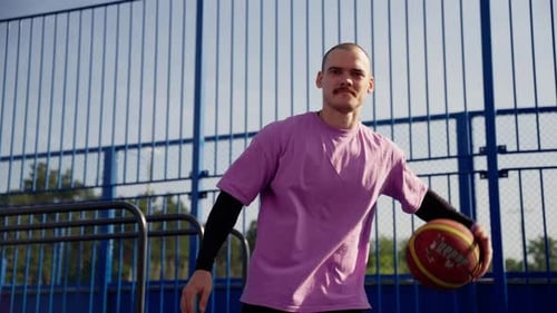 Young Man Holds Basketball and Makes Hand Gesture