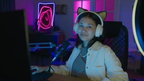 Portrait of Positive Teen Girl Gamer at Computer Desk during Streaming Session