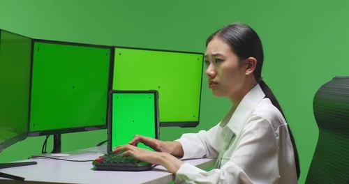 Woman Working With Tablet And Multiple Computer Monitor With Mock Up Green Screen In Green Screen