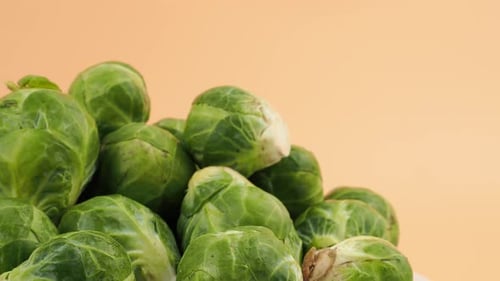 Brussels sprouts rotate on an orange background.